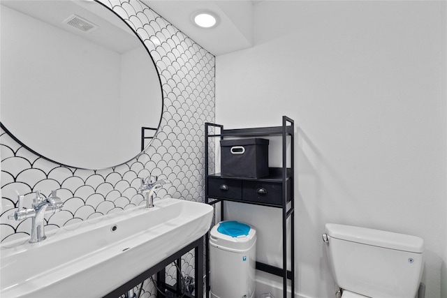 604 Calico Jack Cv, Galveston, TX 77554 - half bathroom with visible vents, toilet, and a sink