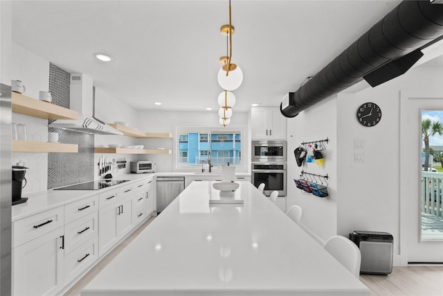 604 Calico Jack Cv, Galveston, TX 77554 - kitchen featuring stainless steel appliances, decorative backsplash, open shelves, a kitchen island, and wall chimney range hood