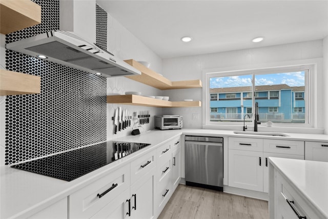 604 Calico Jack Cv, Galveston, TX 77554 - kitchen featuring a sink, light wood-type flooring, wall chimney exhaust hood, white cabinetry, and stainless steel dishwasher