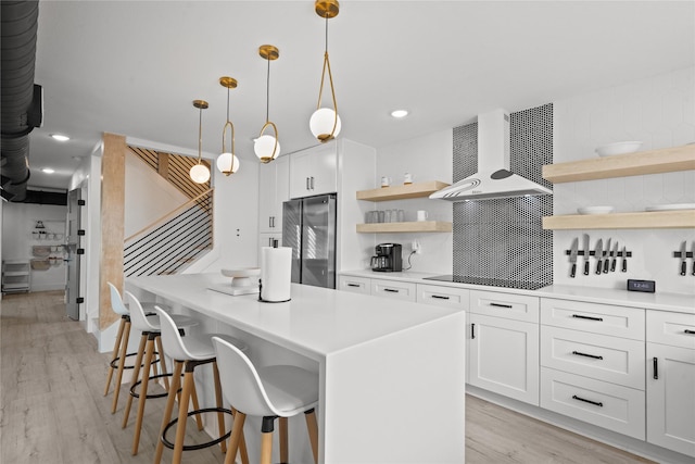 604 Calico Jack Cv, Galveston, TX 77554 - kitchen with open shelves, light wood-style flooring, a kitchen island, freestanding refrigerator, and range hood