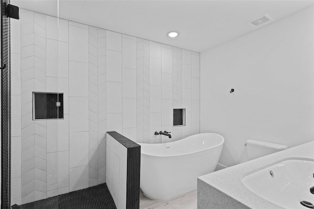 604 Calico Jack Cv, Galveston, TX 77554 - bathroom featuring a sink, visible vents, recessed lighting, wood finished floors, and a freestanding bath