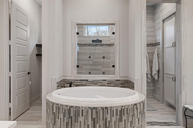 1406 Amber Cv, Willis, TX 77378 - bathroom featuring a garden tub and tiled shower