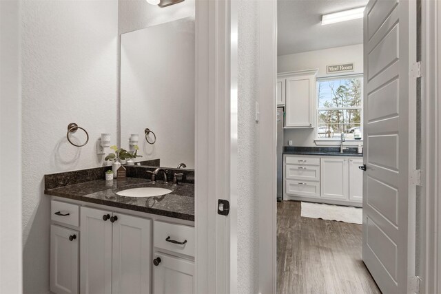1406 Amber Cv, Willis, TX 77378 - bathroom with wood finished floors, vanity, and a textured wall