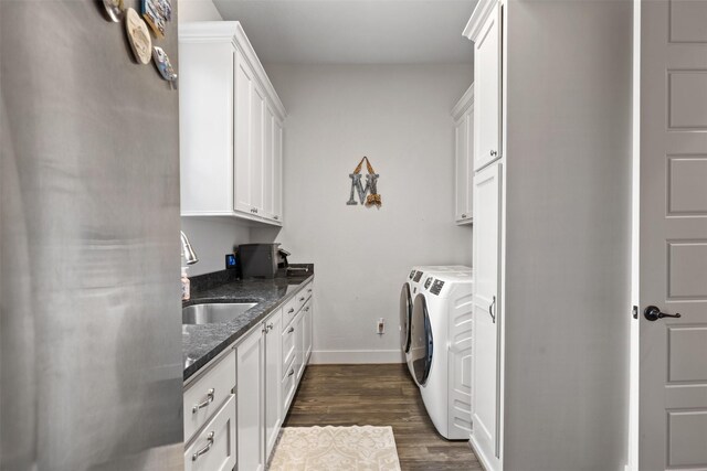 1406 Amber Cv, Willis, TX 77378 - laundry area with cabinet space, washer and clothes dryer, baseboards, and dark wood-style flooring