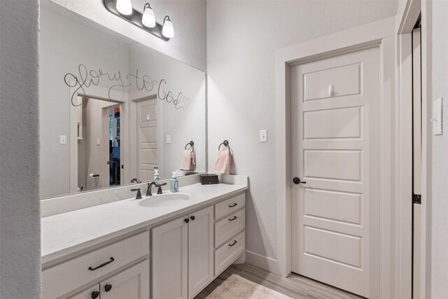 1406 Amber Cv, Willis, TX 77378 - bathroom featuring vanity, baseboards, and wood finished floors