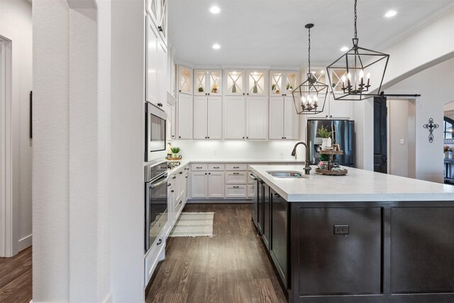 1406 Amber Cv, Willis, TX 77378 - kitchen featuring appliances with stainless steel finishes, a sink, light countertops, dark wood-style flooring, and recessed lighting