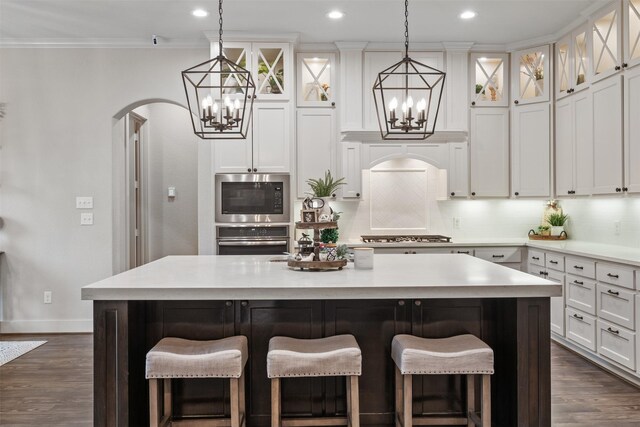 1406 Amber Cv, Willis, TX 77378 - kitchen featuring a chandelier, appliances with stainless steel finishes, a kitchen island, white cabinets, and crown molding