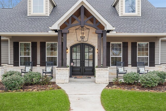 1406 Amber Cv, Willis, TX 77378 - entrance to property with stone siding, a porch, and roof with shingles