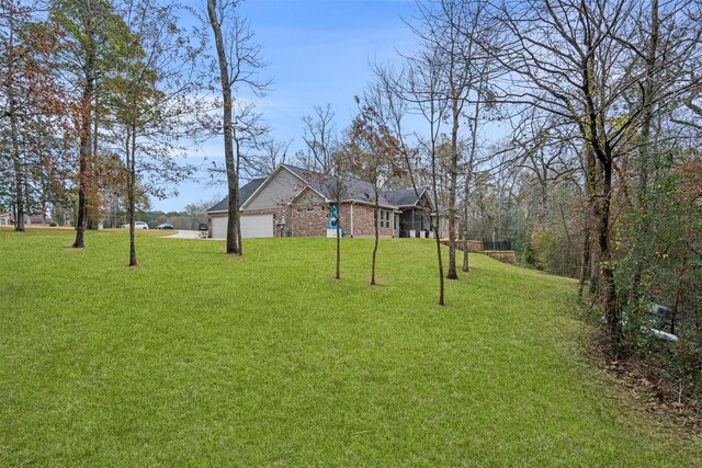 1406 Amber Cv, Willis, TX 77378 - view of green lawn with an attached garage