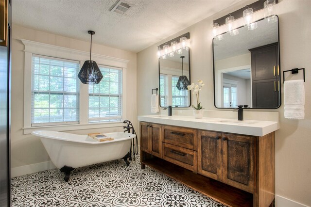 bathroom featuring a sink, a soaking tub, double vanity, baseboards, and visible vents