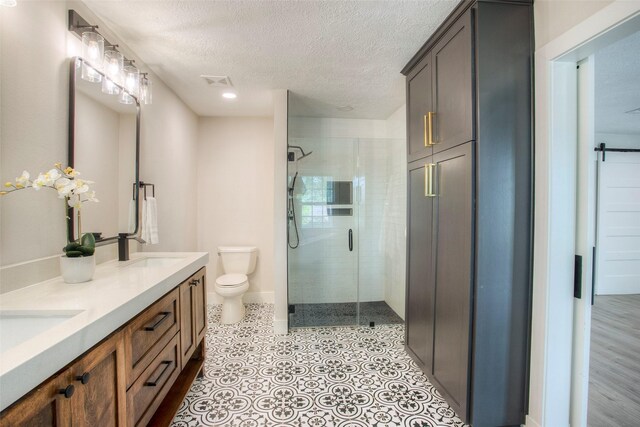 bathroom with a shower stall, a sink, a textured ceiling, toilet, and visible vents
