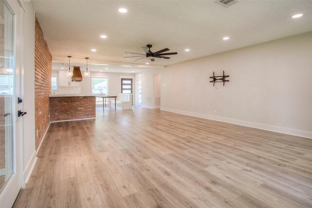 unfurnished living room featuring a textured ceiling, light wood-style floors, ceiling fan, baseboards, and recessed lighting