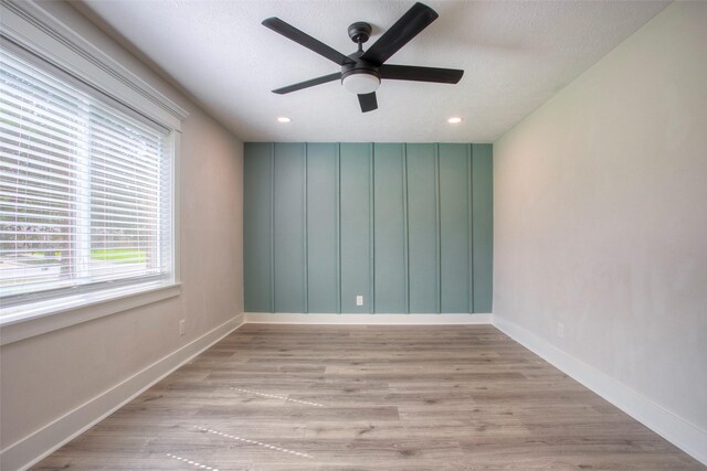 empty room with baseboards, wood finished floors, and ceiling fan