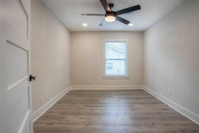 spare room with baseboards, a ceiling fan, wood finished floors, and a textured ceiling