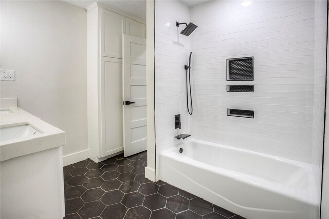 full bath with tile patterned floors, baseboards, a sink, and shower / washtub combination