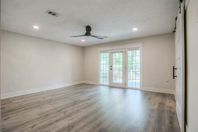 unfurnished room featuring a ceiling fan, visible vents, recessed lighting, and a barn door