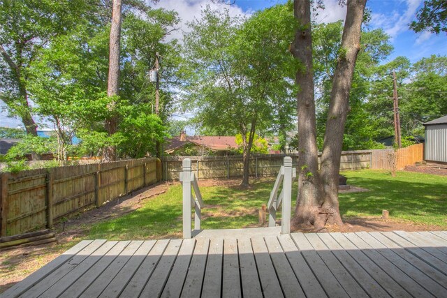 deck with a fenced backyard and a lawn
