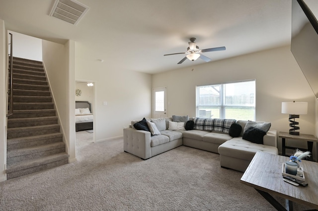 living room with visible vents, carpet flooring, stairs, and ceiling fan