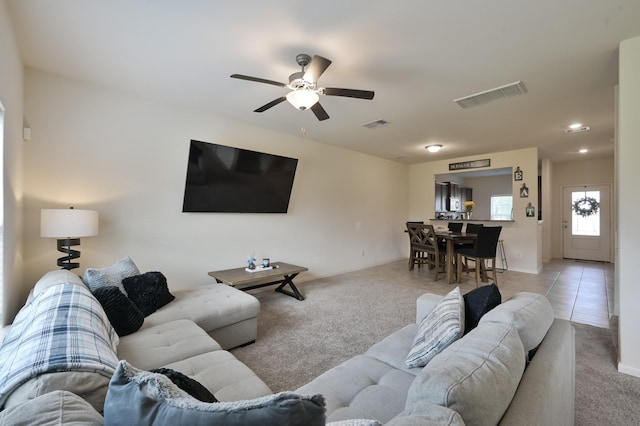 living room featuring a ceiling fan, visible vents, and carpet