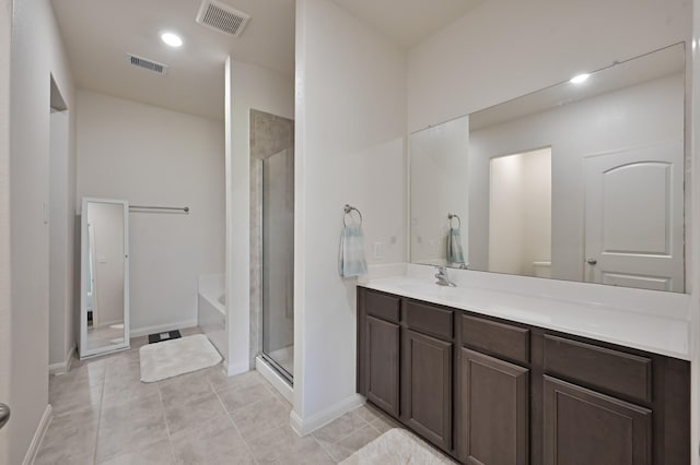 full bathroom featuring visible vents, vanity, a stall shower, and tile patterned floors