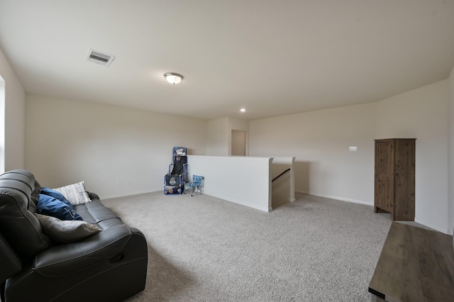 sitting room with baseboards, visible vents, light colored carpet, and an upstairs landing