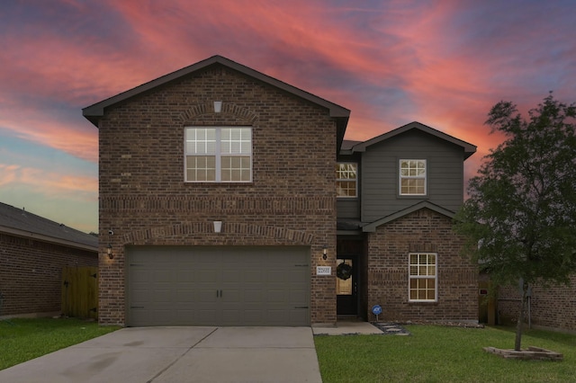 traditional home with brick siding, a yard, driveway, and a garage