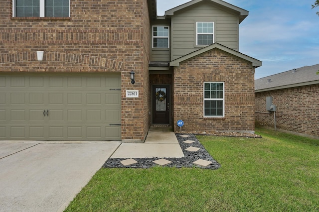 view of front of house featuring brick siding, driveway, and a front lawn