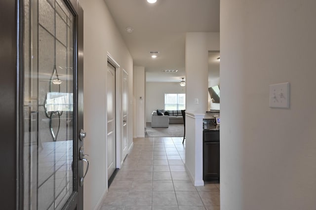 hall with light tile patterned flooring, visible vents, baseboards, and recessed lighting