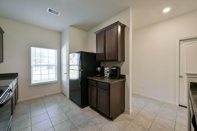 kitchen featuring light tile patterned flooring, dark brown cabinets, baseboards, visible vents, and black appliances