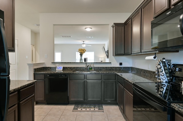 kitchen featuring dark stone countertops, visible vents, a sink, black appliances, and ceiling fan
