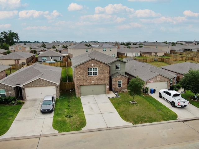 view of front of house featuring a garage, a front lawn, a residential view, and concrete driveway