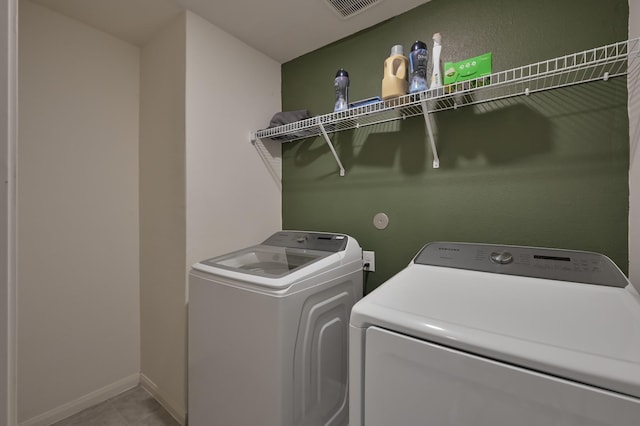 laundry room featuring light tile patterned floors, laundry area, baseboards, visible vents, and independent washer and dryer