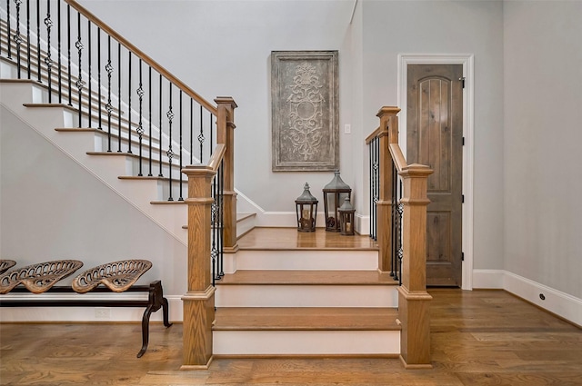 staircase with wood finished floors and baseboards