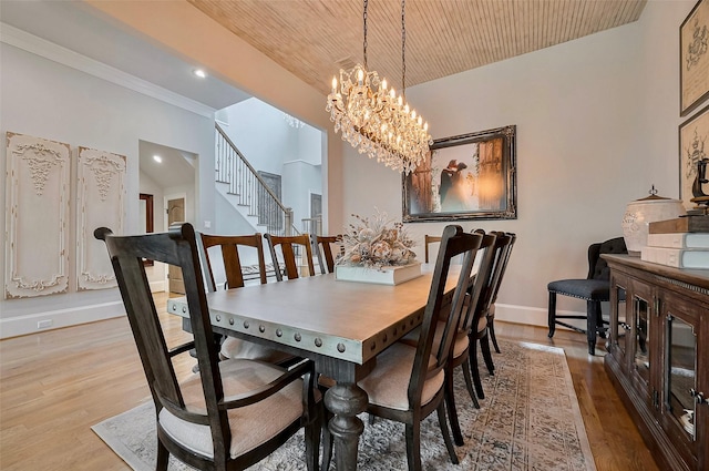 dining space with a chandelier, baseboards, wood finished floors, recessed lighting, and stairway