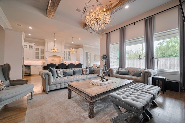 living room with a chandelier, wine cooler, light wood-style flooring, ornamental molding, and recessed lighting