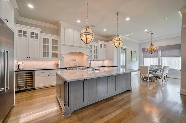 kitchen featuring wine cooler, a chandelier, built in refrigerator, recessed lighting, and decorative backsplash