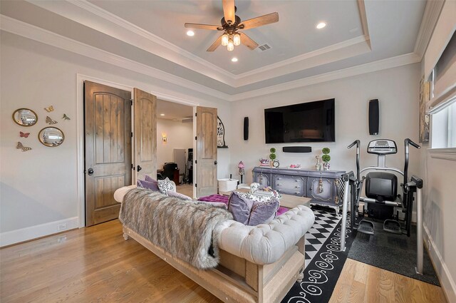 living area featuring ceiling fan, wood finished floors, a tray ceiling, recessed lighting, and ornamental molding