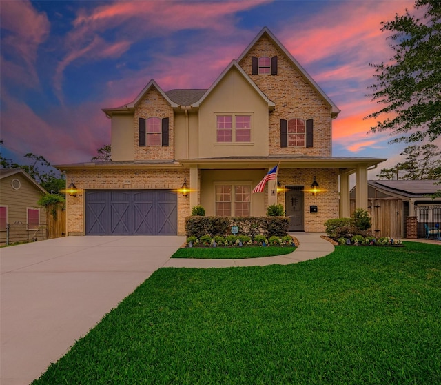 traditional-style house featuring driveway, brick siding, stucco siding, and an attached garage