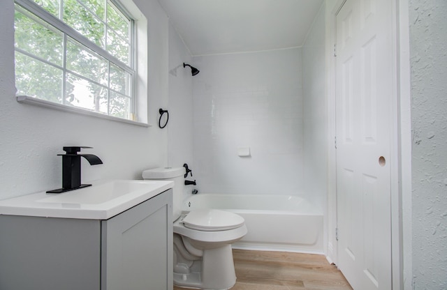 full bath with a textured wall, wood finished floors, tub / shower combination, and toilet