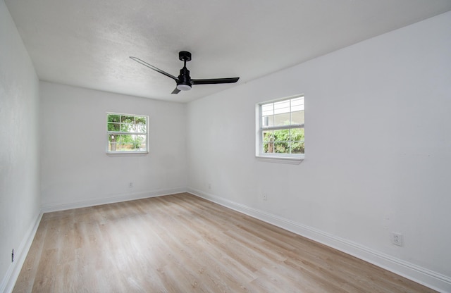 unfurnished room with light wood-style floors, a ceiling fan, and baseboards