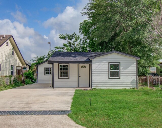 ranch-style home featuring fence and a front lawn