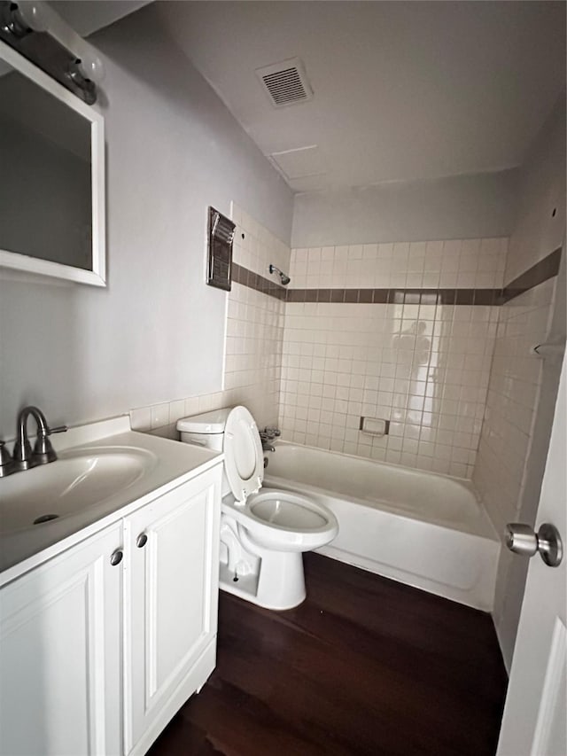 bathroom featuring bathing tub / shower combination, wood finished floors, visible vents, toilet, and vanity