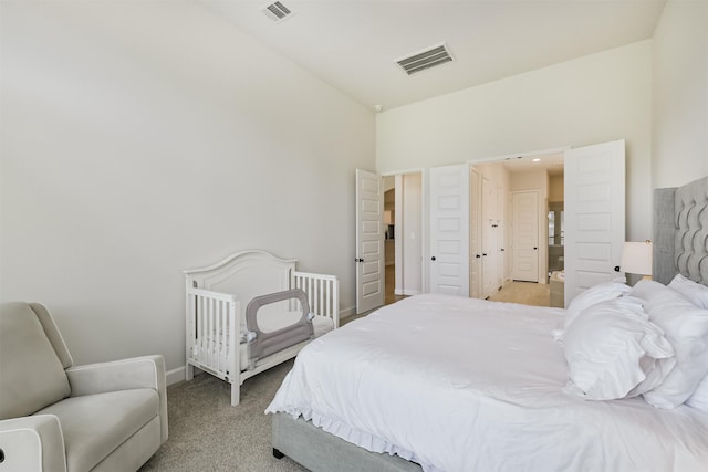 bedroom with baseboards, visible vents, and light colored carpet