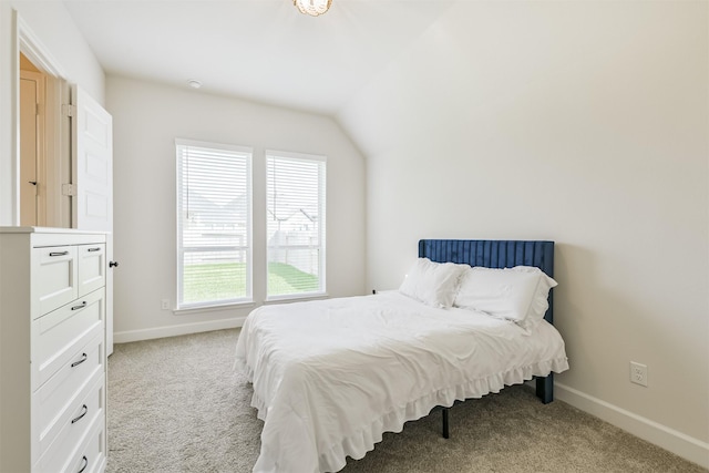 bedroom featuring carpet, lofted ceiling, and baseboards