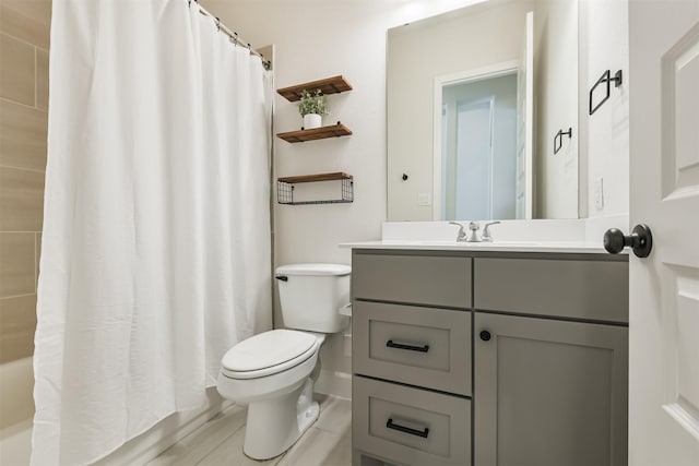 full bathroom featuring tile patterned floors, shower / bath combo, vanity, and toilet