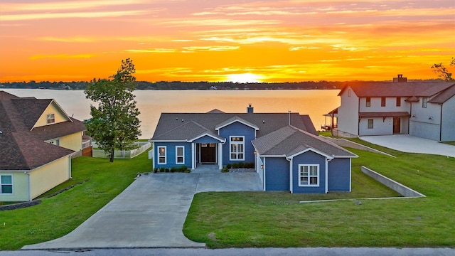 254 Peninsula Dr, Livingston, TX 77351 - view of front of house featuring a garage, driveway, a front lawn, and a water view