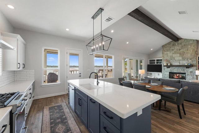 254 Peninsula Dr, Livingston, TX 77351 - kitchen featuring stainless steel appliances, a sink, visible vents, a fireplace, and dark wood-type flooring