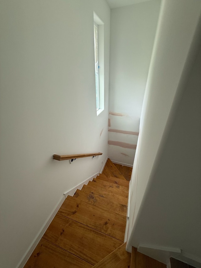 stairway with baseboards and wood finished floors