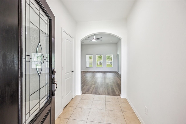 22702 Crate Falls Dr, Hockley, TX 77447 - foyer entrance with baseboards, arched walkways, ceiling fan, and light tile patterned floors