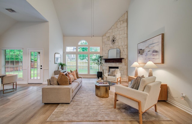1840 Leela Springs Dr, Conroe, TX 77304 - living room featuring high vaulted ceiling, a stone fireplace, wood finished floors, and visible vents